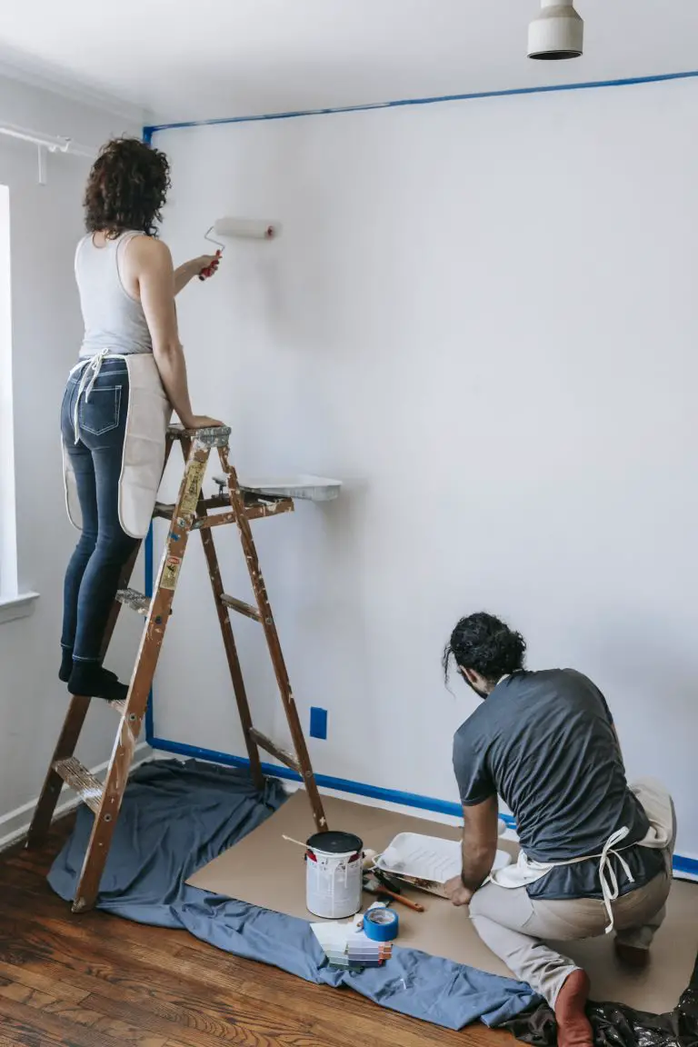Couple painting the wall white